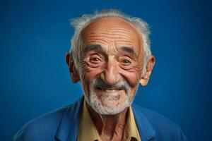 Senior man smiling happily on blue background photo