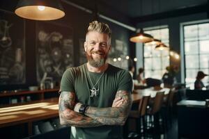 Male barista with tattoo standing in coffee shop photo