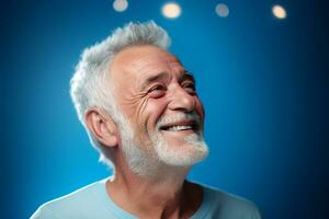 Senior man smiling happily on blue background photo