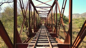 Aerial view drone crossing over old bridge with rails. video