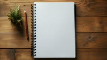 A white blank notepad with pages lies on a wooden table and copy space photo