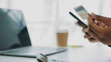 Making Financial Transaction. Closeup of black girl showing credit card and using cell phone with empty screen, mock up video