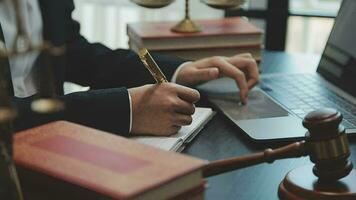 Business and lawyers discussing contract papers with brass scale on desk in office. Law, legal services, advice, justice and law concept picture with film grain effect video