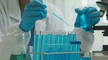 Health care researchers working in life science laboratory. Young female research scientist and senior male supervisor preparing and analyzing microscope slides in research lab. video