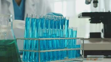 Health care researchers working in life science laboratory. Young female research scientist and senior male supervisor preparing and analyzing microscope slides in research lab. video