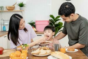 familia tiempo, desayuno, ocupaciones juntos durante el vacaciones. padres y niños son teniendo un comida juntos durante el vacaciones. nuevo hogar para familia en mañana, disfrutar, fin de semana, vacante hora foto