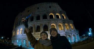 Selfie of tourists against Coliseum at night video