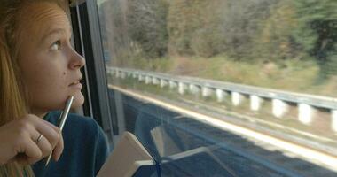Woman taking notes or drawing in train video