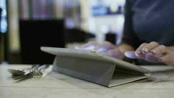 mujer en café utilizando tableta ordenador personal a enviar un mensaje video