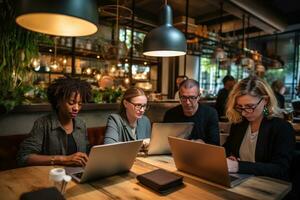 A group of business people sitting behind a desk with laptops photo