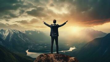 A business person standing on top of a mountain photo