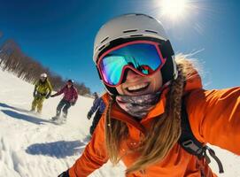 A woman wearing an orange jacket is selfieing on a snowy slope photo