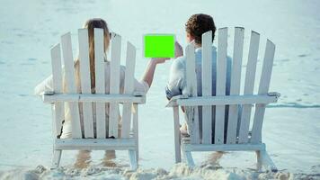 Frau und Mann Sitzung auf das Strand suchen beim Pad mit Grün Bildschirm video