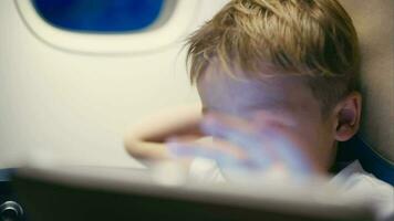 Little boy using tablet computer during flight video