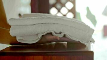 Woman putting fresh towels and flower on the table video