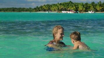 Mother and son playing in clear sea water video