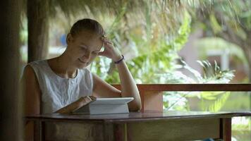 vrouw met behulp van tablet pc buiten zitten in de tropen video