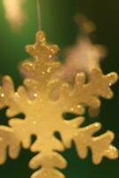 blurred golden snow flakes on dark green background photo