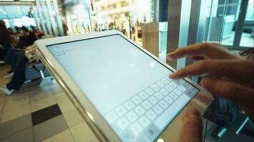 Woman using tablet PC in waiting room of airport or station video