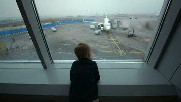 Little boy looking out the window at airport video