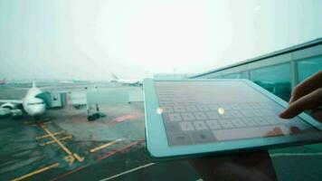 mit Tablette Computer durch das Fenster beim Flughafen video