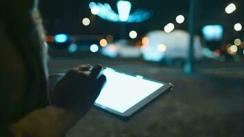 Woman using touch pad while walking in city at night video