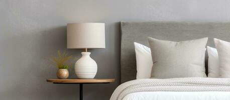 Modern bedroom with a white bed grey pillow black lamp on wooden table photo