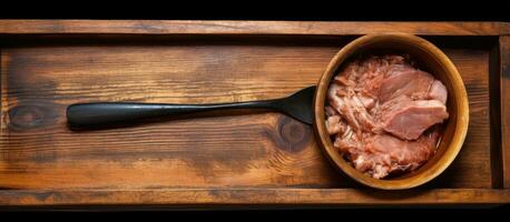 Wooden tray with pork and spoon photo
