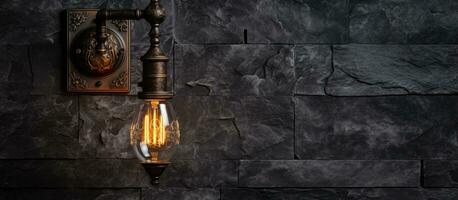 Industrial wall lamp against dark stone wall photo