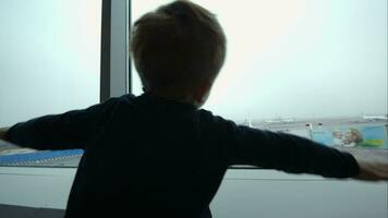 Little boy showing plane with hands looking at it out the window video