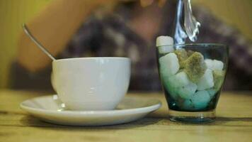 Frau Putten Zucker in Tee Tasse mit Zange video