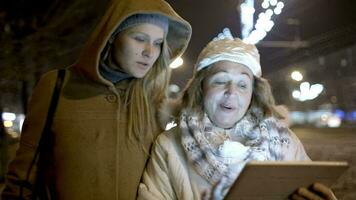 Two women walking with pad outdoor in the cold evening video