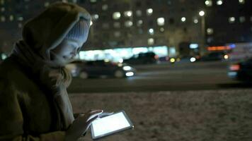 Woman typing message on pad while walking in the evening video