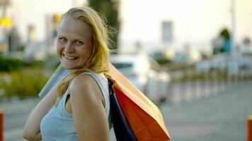 Smiling woman with shopping bags outdoor video