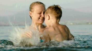 Mutter und Sohn planschen Wasser im Meer video