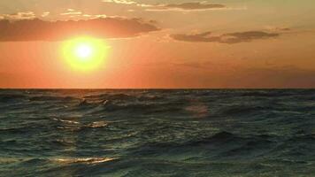 dourado pôr do sol sobre rude mar video