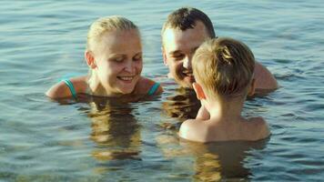 Eltern und Sohn im Meer während Sommer- Ferien video
