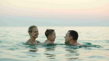 gelukkig familie van drie het baden in zee video