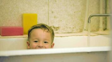 pequeño sonriente chico sentado en bañera video