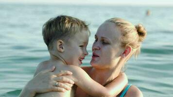 Son and mother bathing in sea video