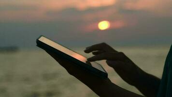 utilizando touchpad en el playa a puesta de sol video