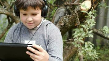 pojke i hörlurar med pekplatta utomhus- video