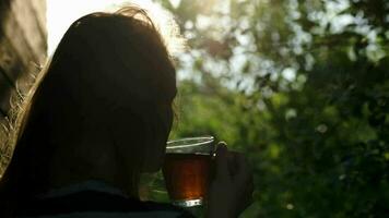 mulher tendo chá ao ar livre durante pôr do sol video