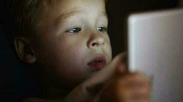Boy with tablet PC before bedtime video