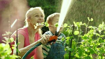 mamá y hijo riego el jardín juntos video