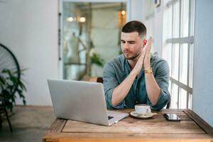 A male, Handsome Freelance man sit and wait while using their laptops to upload files. freelance concept. photo