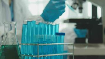 Health care researchers working in life science laboratory. Young female research scientist and senior male supervisor preparing and analyzing microscope slides in research lab. video