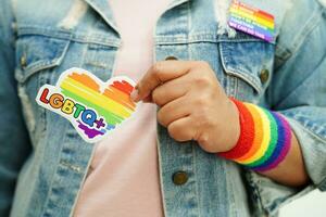 mujer asiática con bandera del arco iris, derechos de símbolos lgbt e igualdad de género, mes del orgullo lgbt en junio. foto