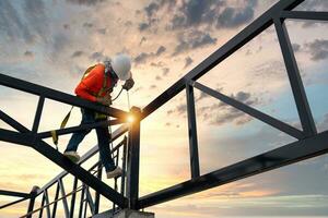 un soldadores en riesgo áreas acero techo braguero soldadores con la seguridad dispositivos a evitar caídas desde un altura en el construcción sitio. foto