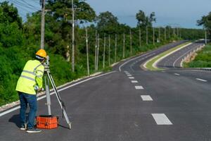 A surveyor engineer worker making measuring with theodolite instrument equipment during construction road works, Civil Engineers, Surveyor equipment. photo